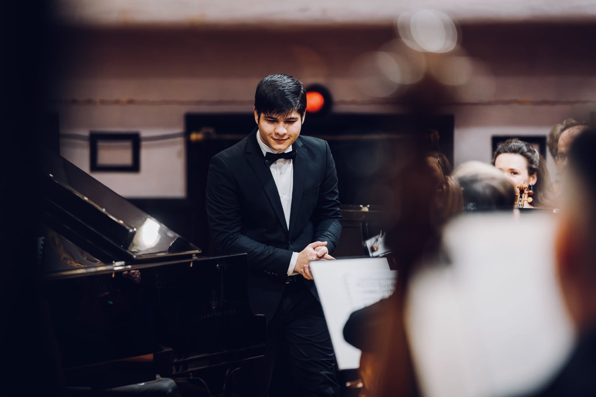 Robert Bascoveanu on stage beside a grand piano