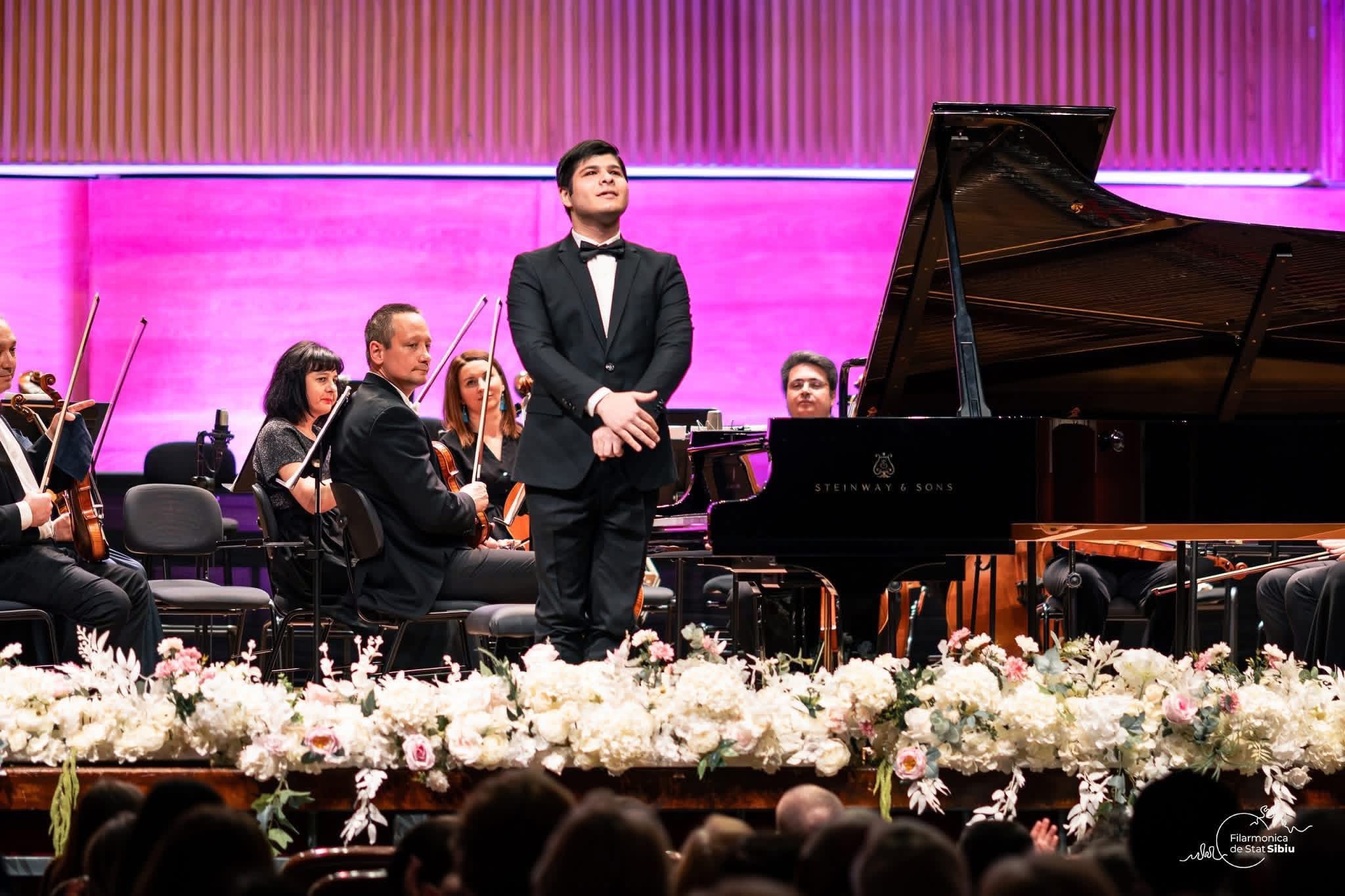 Robert Bascoveanu seated beside a Bösendorfer grand piano
